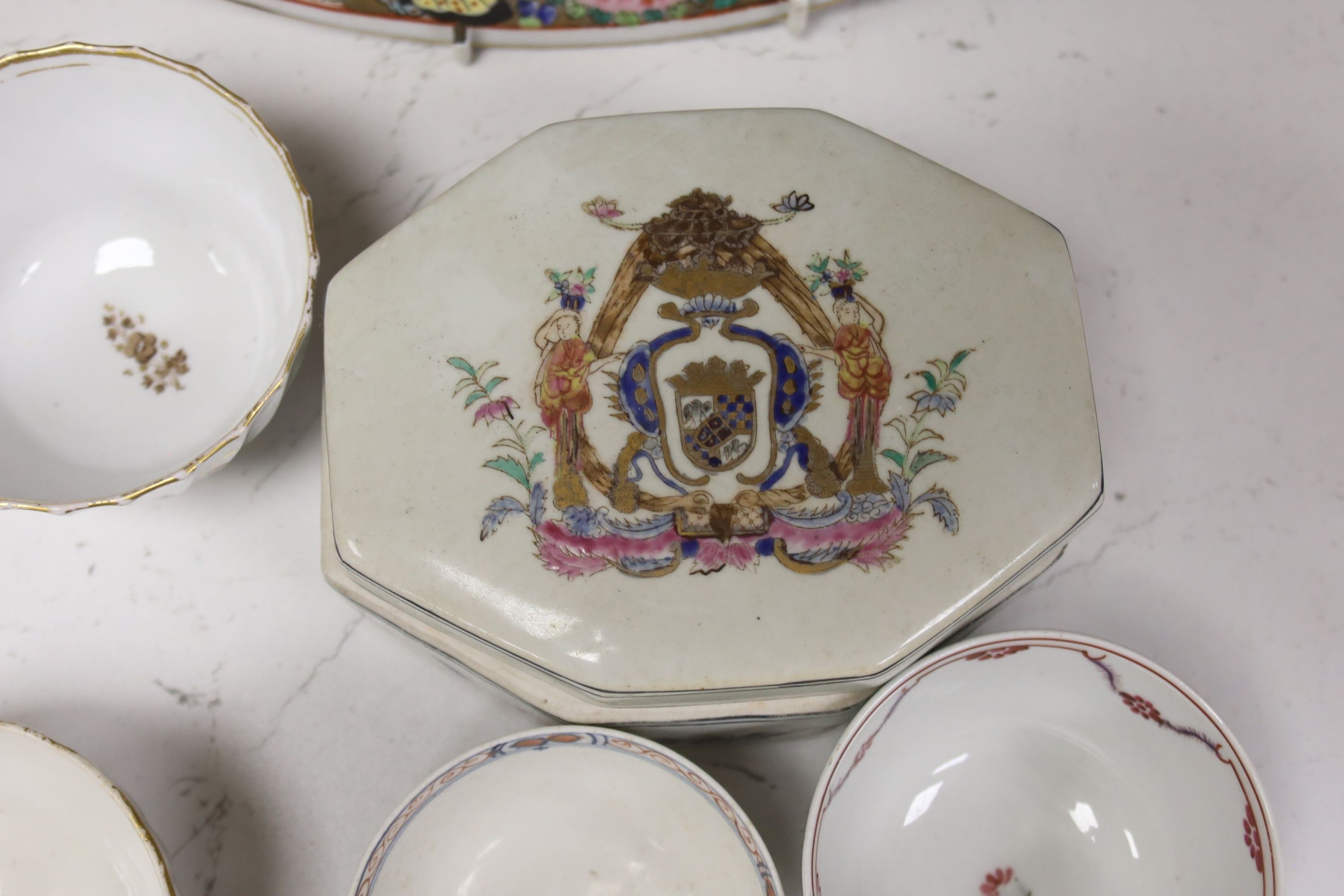 Seven 18th century English porcelain tea bowls, an armorial box and cover and a famille rose dish, diameter 30cm